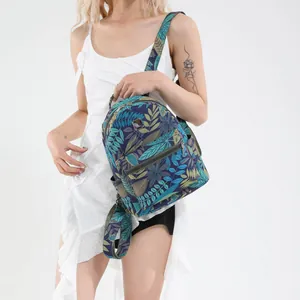 Tropical leaf print large backpack with front pocket shown on a female model