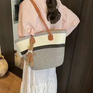 Chic black and white striped woven tote bag with brown leather straps and bunny charm