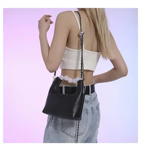 Détail du sac demi-lune en cuir noir avec poignée en perles et chaîne argentée
