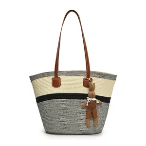 Large woven straw tote bag with brown leather straps and cute rabbit charm detail