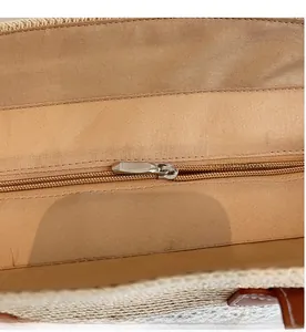 Detailed view of the smooth nylon zipper and silver alloy hardware on a striped woven tote bag