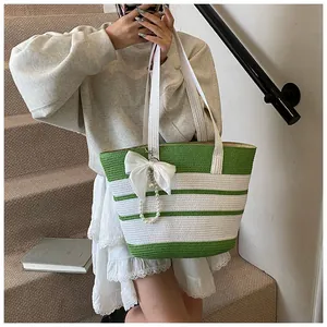 Dettaglio borsa tote intrecciata a righe bianche e verdi con fiocco di seta