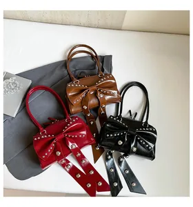 Trois sacs à main en cuir rouge, marron et noir avec nœuds et rivets métalliques argent