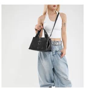 Borsa a tracolla in pelle nera con croce gotica argento su un outfit bianco elegante