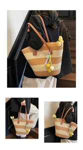 Detail of striped woven tote bag with leather handles and decorative tulip charm