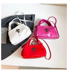 Dettaglio borse punk nei colori bianco, rosso e magenta con croce in metallo decorativa