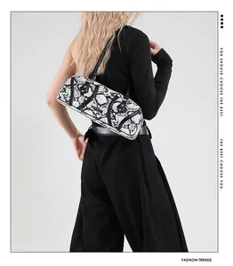 Close-up of black and white snakeskin pattern cylindrical shoulder bag with rivets