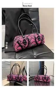 Detailed view of a rose red snakeskin print Boston bag with black handles and metal buckles