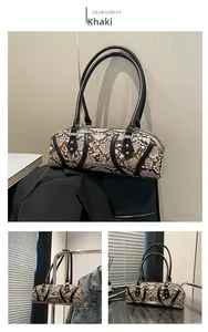 Detail of khaki snakeskin pattern on women's vintage baguette bag with metal rivets