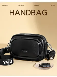 Nahaufnahme der schwarzen Handtasche mit Litschi-Struktur, drei Zippern und Textilgurt