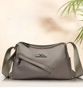 Vue détaillée du sac en nylon taupe imperméable avec logo en métal et poche zippée biais