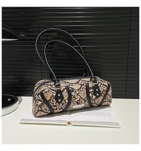 Detailed macro view of snakeskin pattern on cylindrical boston bag with silver rivets