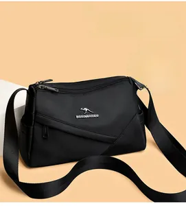 Gros plan d'un sac bandoulière en nylon noir avec plusieurs compartiments à fermeture éclair