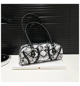 Detailed view of snakeskin pattern texture with black leather handles and silver rivets