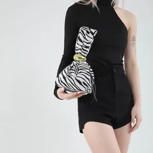Chic zebra pattern handbag for women featuring a gold oval metal clasp and pleated design