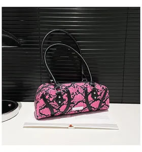 Detail of pink and black snakeskin pattern shoulder bag with silver rivets and leather straps
