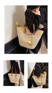 Detail of beige woven tote bag with white lace hollow craft and brown leather straps
