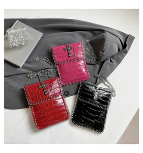 Detail of punk style crossbody bags featuring crocodile texture and silver cross charms