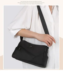 Détail du sac bandoulière en nylon noir avec logo kangourou et coutures géométriques