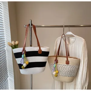 Close-up of woven straw tote bags featuring leather straps and colorful crochet pendants