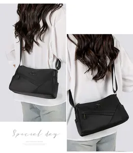 Détail d'un sac de banlieue léger en nylon noir avec logo kangourou métallique et poches