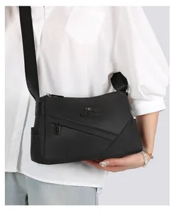 Détail du sac polochon noir avec compartiments zippés et texture en nylon durable