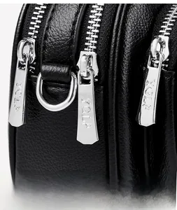 Makro-Detailaufnahme der schwarzen Ledertasche mit silbernen Reißverschlüssen