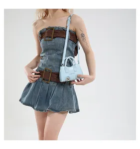 Detail of light blue mini bag with silver metal studs and thin shoulder strap