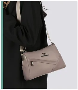 Détail du sac bandoulière en nylon kaki clair avec logo kangourou en métal et large sangle