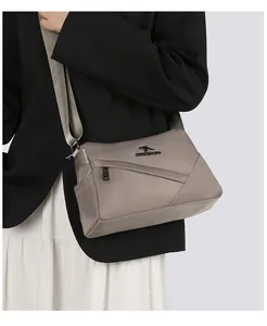 Détail du sac bandoulière en nylon kaki avec logo kangourou en métal et zip élégant