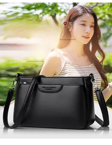 Close-up of black litchi pattern leather crossbody bag with silver hardware detail