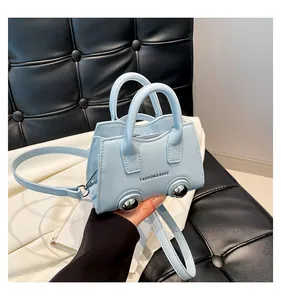 Close-up of light blue mini bag with silver metal ball feet and fine leather texture