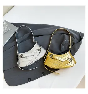 Detailansicht silberner und goldener Taschen mit Krokodil-Prägung aus Lederstruktur