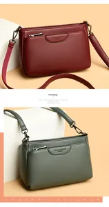 Detail view of burgundy and sage green crossbody bags in textured lychee grain leather