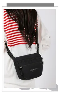 Close-up of double zippers and nylon texture on the black casual crossbody bag