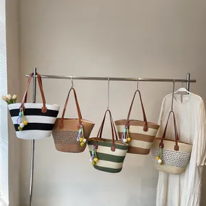 Large woven straw tote bag with striped patterns and colorful tassels for summer beach style
