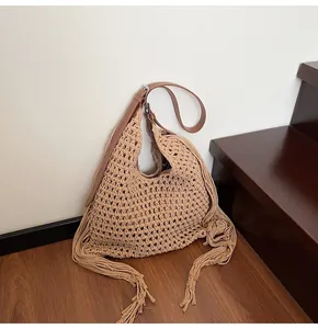 Detail der handgewebten beige Tasche mit langen Fransen und braunem Leder-Schultergurt