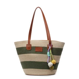 Striped straw woven tote bag with brown leather straps and colorful pompom charms