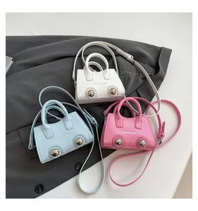 Detailed view of mini crossbody bags in white, pink and blue with silver metal studs