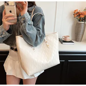 Close-up of quilted cream tote bag with elegant diamond texture and shoulder straps