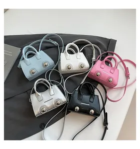 Flat lay of mini crossbody handbags in five colors with metal rivets and fashion logo