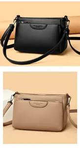 Close-up of litchi grain leather crossbody bags in black and beige with silver hardware