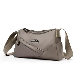 Vue de face d'un sac bandoulière polyvalent en nylon taupe avec bandoulière large