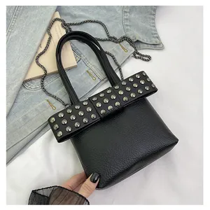 Détail du nœud à rivets sur sac en cuir grainé noir avec bandoulière chaîne