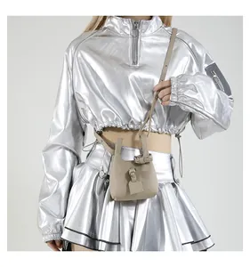 Mini-Eimertasche mit Litschi-Struktur am Model in futuristischem Outfit getragen