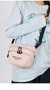 Detail of light pink nylon crossbody bag with multi-layer zippers and adjustable strap