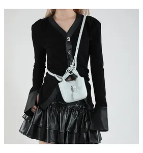 Hellblaue Eimer-Tasche mit Lychee-Muster und Lederriemen an einem Modeloutfit