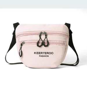 Detail of light pink nylon crossbody bag with dual zippers and adjustable black strap