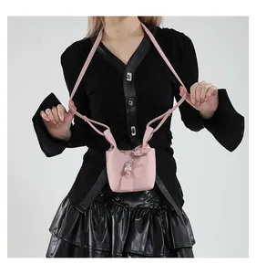 Detail der rosa Mini-Beuteltasche mit Lychee-Muster, Lederanhänger und Schnalle