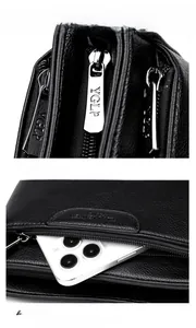 Detail view of black pebble leather crossbody bag with metal zipper and phone pocket